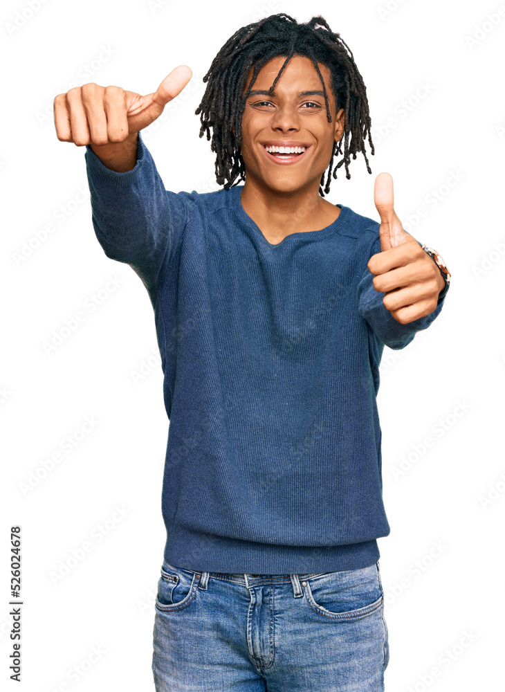 Young african american man wearing casual winter sweater approving doing positive gesture with hand, thumbs up smiling and happy for success. winner gesture. Young african american man wearing casual winter sweater approving doing positive gesture with hand, thumbs up smiling and happy for success. winner gesture.