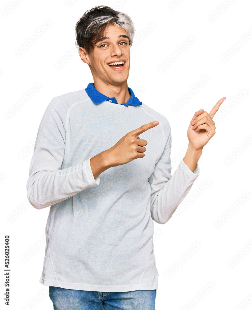 Young hispanic man wearing casual clothes smiling and looking at the camera pointing with two hands and fingers to the side. Young hispanic man wearing casual clothes smiling and looking at the camera pointing with two hands and fingers to the side.