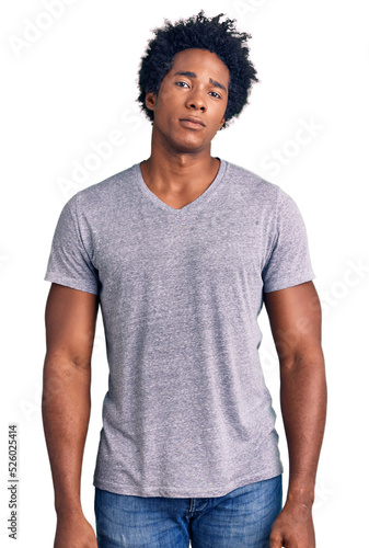 Handsome african american man with afro hair wearing casual clothes relaxed with serious expression on face. simple and natural looking at the camera.