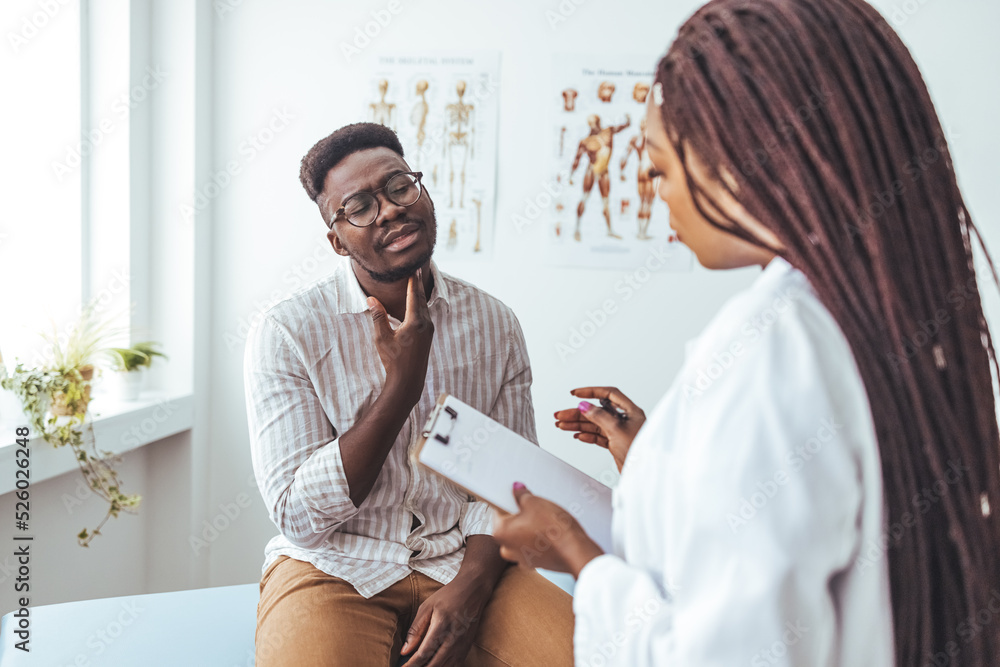 Obraz premium Discussing a sore throat at a doctor's appointment. Shot of a doctor examining a man’s throat during a consultation. Patient showing pain at Throat to her otolaryngologist.