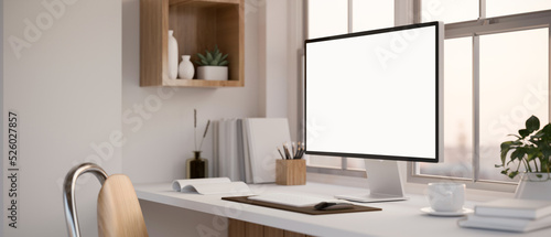 Modern white working space with PC computer white screen mockup and decor on the table photo