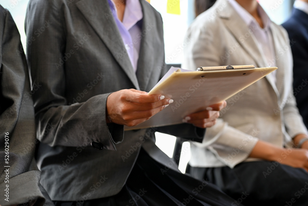 A female candidate reading an interview information on the paper. job interview. cropped A female candidate reading an interview information on the paper. job interview. cropped