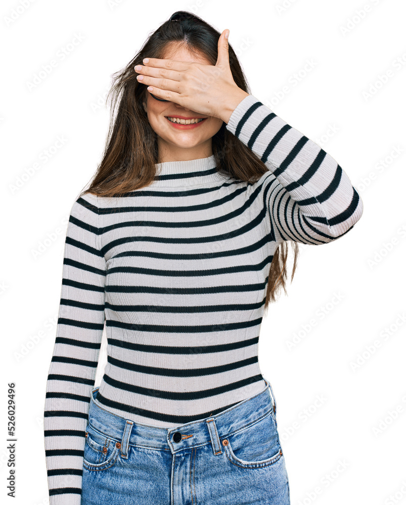 Young beautiful teen girl wearing casual clothes and glasses smiling and laughing with hand on face covering eyes for surprise. blind concept. Young beautiful teen girl wearing casual clothes and glasses smiling and laughing with hand on face covering eyes for surprise. blind concept.