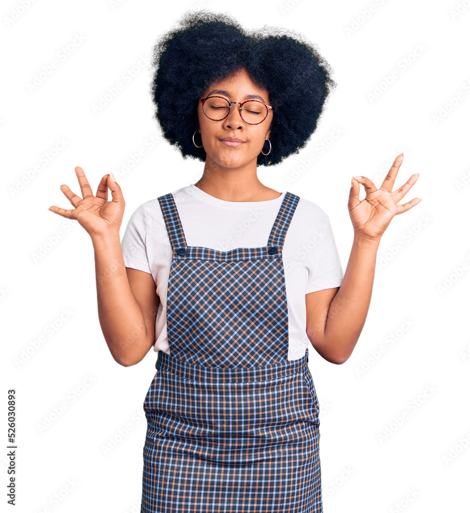 Young african american girl wearing casual clothes relax and smiling with eyes closed doing meditation gesture with fingers. yoga concept. Young african american girl wearing casual clothes relax and smiling with eyes closed doing meditation gesture with fingers. yoga concept.