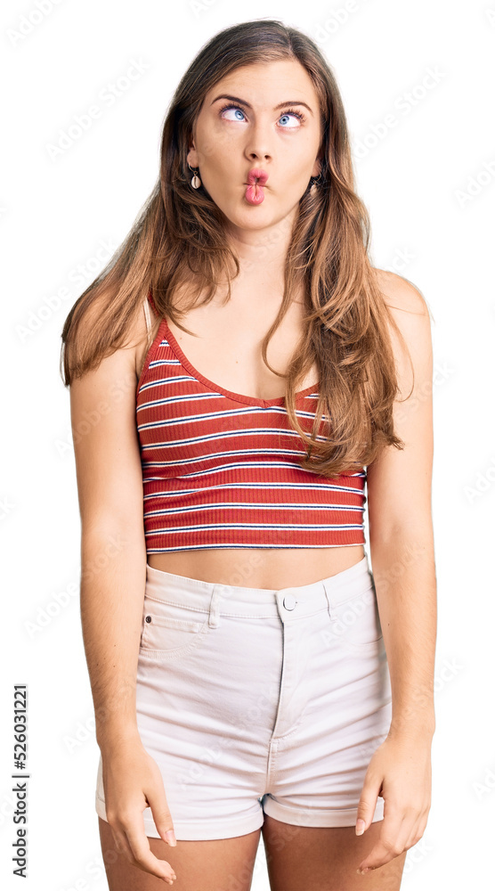 Beautiful caucasian young woman wearing casual clothes making fish face with lips, crazy and comical gesture. funny expression. Beautiful caucasian young woman wearing casual clothes making fish face with lips, crazy and comical gesture. funny expression.