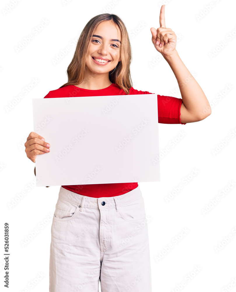Young beautiful blonde woman holding blank empty banner surprised with an idea or question pointing finger with happy face, number one Young beautiful blonde woman holding blank empty banner surprised with an idea or question pointing finger with happy face, number one