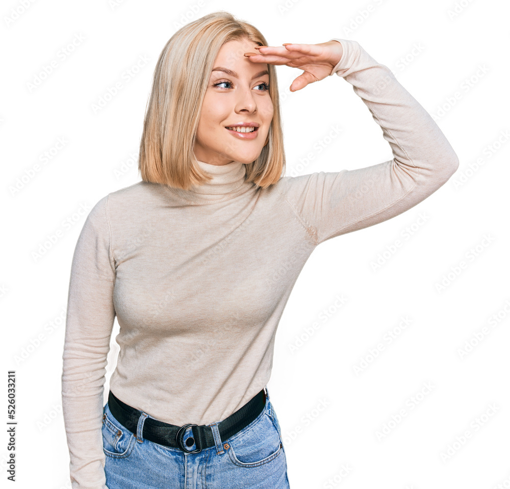 Fototapeta premium Young blonde woman wearing casual clothes very happy and smiling looking far away with hand over head. searching concept.