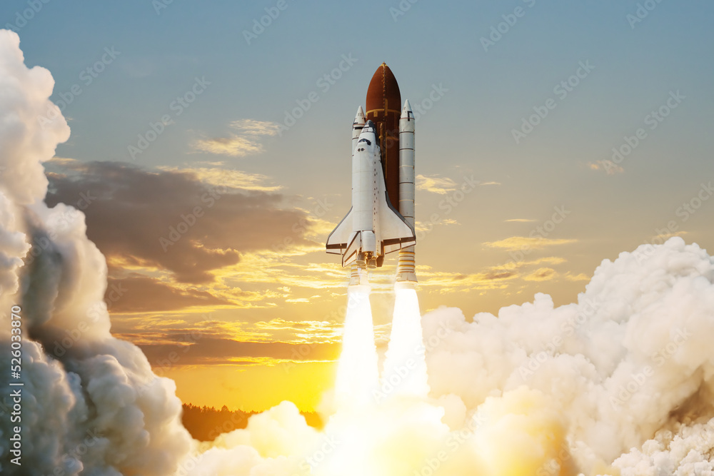 Obraz premium Spaceship lift off. Space shuttle with smoke and blast takes off into space on a background of sunset. Successful start of a space mission. Elements of this image furnished by NASA.