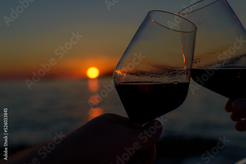 two glasses of wine with a sunset 