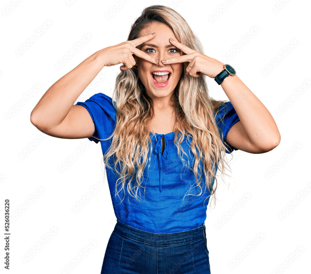 Young blonde woman wearing casual clothes doing peace symbol with fingers over face, smiling cheerful showing victory Young blonde woman wearing casual clothes doing peace symbol with fingers over face, smiling cheerful showing victory