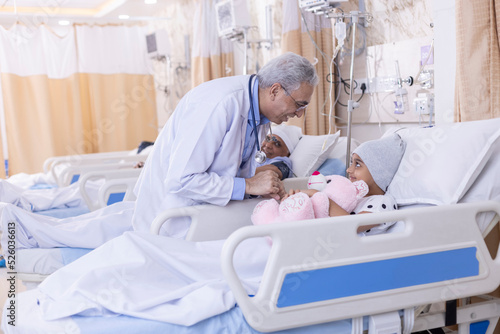 Doctor examining and having fun with little girl patient at hospital 