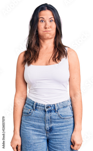 Young beautiful brunette woman wearing casual sleeveless t-shirt puffing cheeks with funny face. mouth inflated with air, crazy expression.
