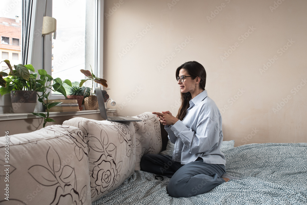 Young freelancer business woman talking on video call from home on her laptop computer while she is sick. Ill female have web conference about important business solutions with her colleagues. Young freelancer business woman talking on video call from home on her laptop computer while she is sick. Ill female have web conference about important business solutions with her colleagues.