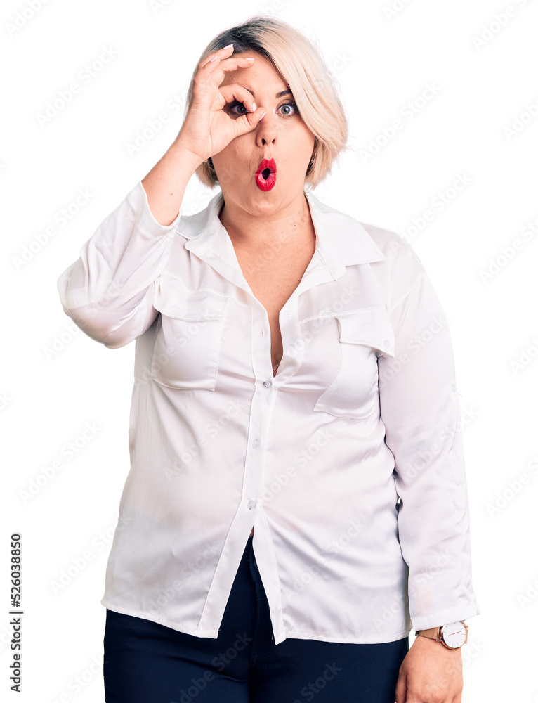 Young blonde plus size woman wearing casual shirt doing ok gesture shocked with surprised face, eye looking through fingers. unbelieving expression. Young blonde plus size woman wearing casual shirt doing ok gesture shocked with surprised face, eye looking through fingers. unbelieving expression.