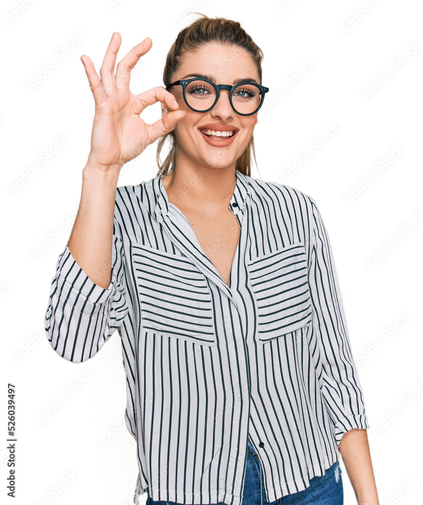 Young caucasian woman wearing business shirt and glasses smiling positive doing ok sign with hand and fingers. successful expression. Young caucasian woman wearing business shirt and glasses smiling positive doing ok sign with hand and fingers. successful expression.