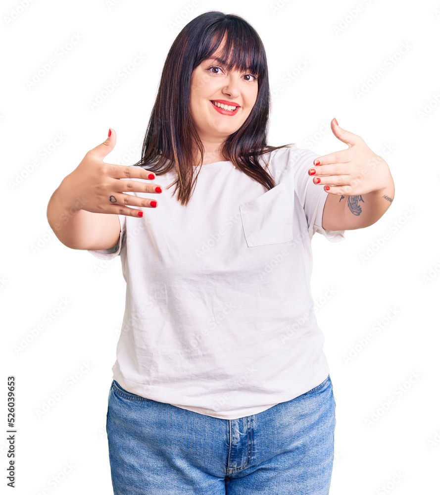 Young plus size woman wearing casual clothes looking at the camera smiling with open arms for hug. cheerful expression embracing happiness. Young plus size woman wearing casual clothes looking at the camera smiling with open arms for hug. cheerful expression embracing happiness.