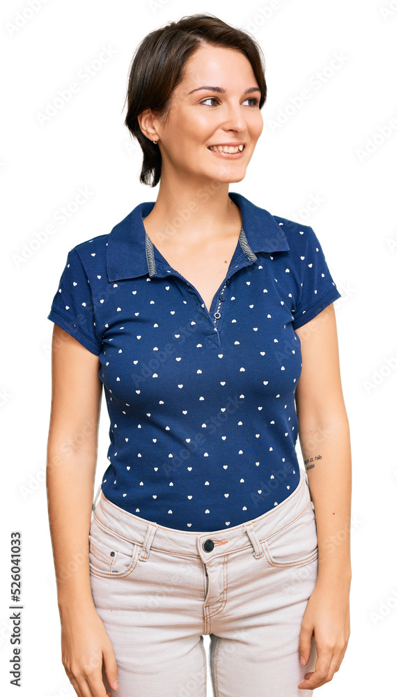 Young brunette woman with short hair wearing casual clothes looking away to side with smile on face, natural expression. laughing confident. Young brunette woman with short hair wearing casual clothes looking away to side with smile on face, natural expression. laughing confident.