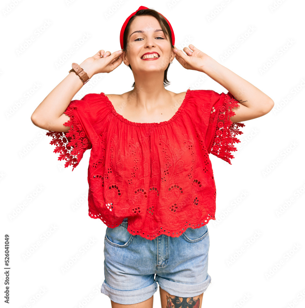 Young brunette woman with short hair wearing casual summer clothes and diadem smiling pulling ears with fingers, funny gesture. audition problem Young brunette woman with short hair wearing casual summer clothes and diadem smiling pulling ears with fingers, funny gesture. audition problem