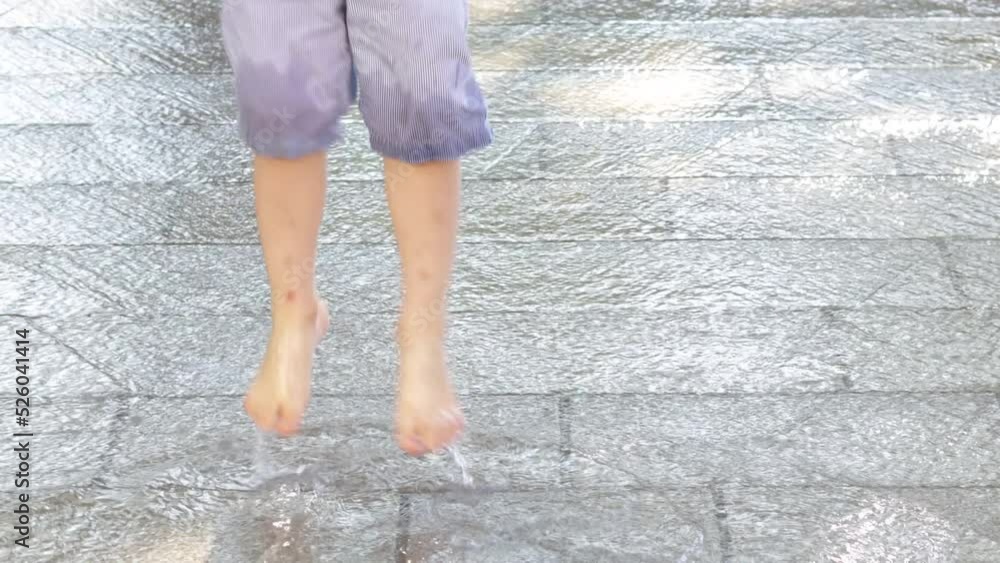 water falls on sidewalk brick wall road,child kid is playing jumping having fun in sunny summer day.barefoot boy runs touching the road with palm,splashing.cascate waterfall in city for heat days,cool water falls on sidewalk brick wall road,child kid is playing jumping having fun in sunny summer day.barefoot boy runs touching the road with palm,splashing.cascate waterfall in city for heat days,cool