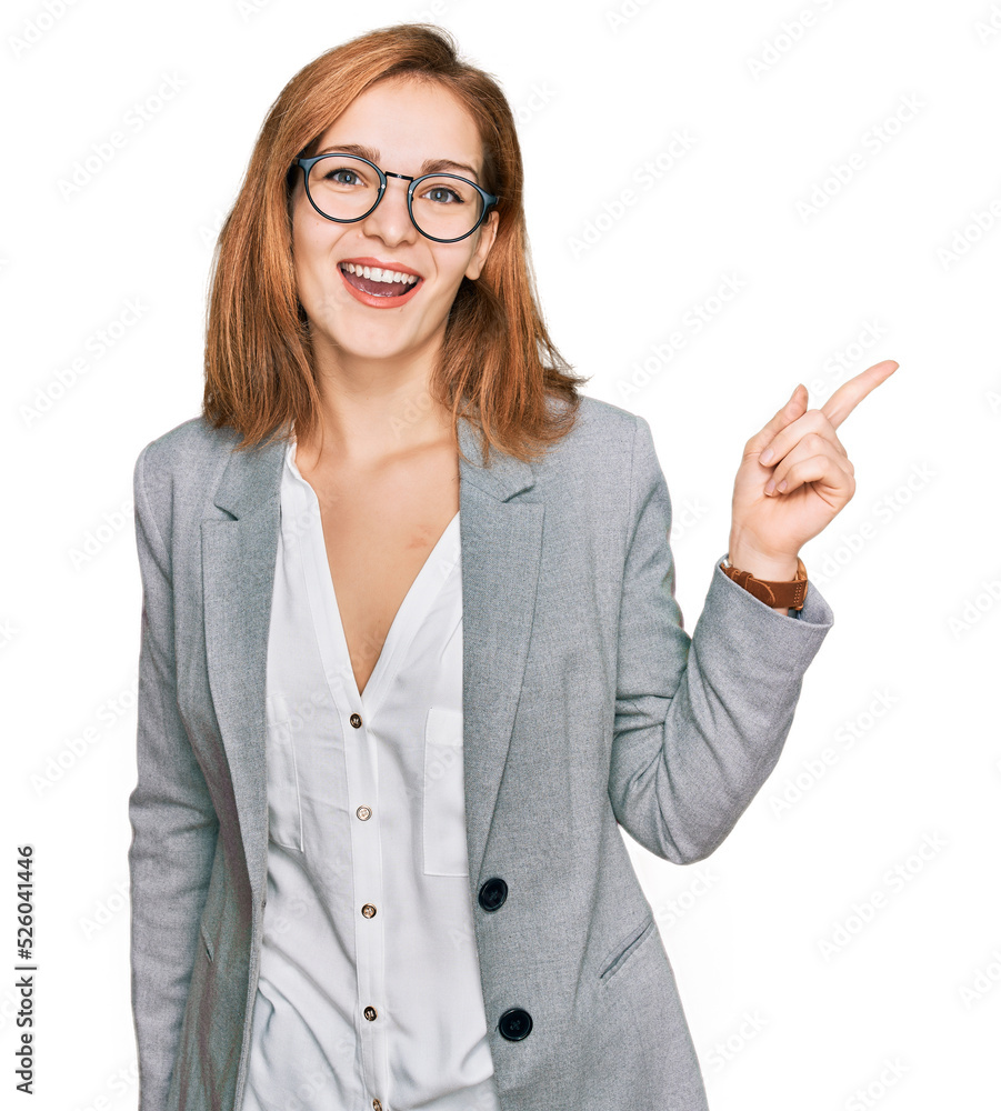 Young caucasian woman wearing business style and glasses with a big smile on face, pointing with hand finger to the side looking at the camera. Young caucasian woman wearing business style and glasses with a big smile on face, pointing with hand finger to the side looking at the camera.