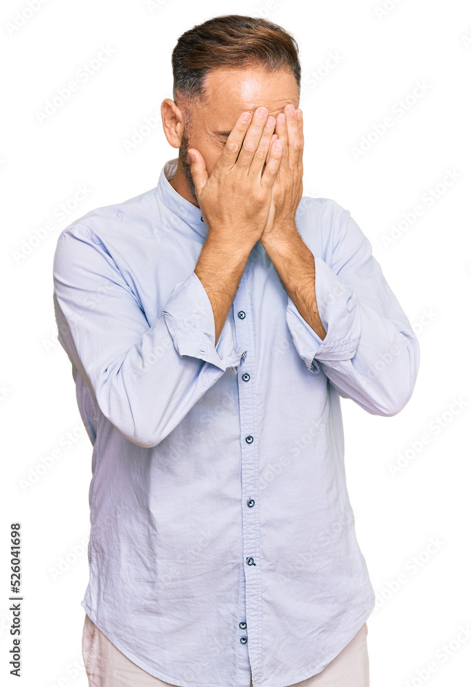 Handsome middle age man wearing business shirt with sad expression covering face with hands while crying. depression concept. Handsome middle age man wearing business shirt with sad expression covering face with hands while crying. depression concept.