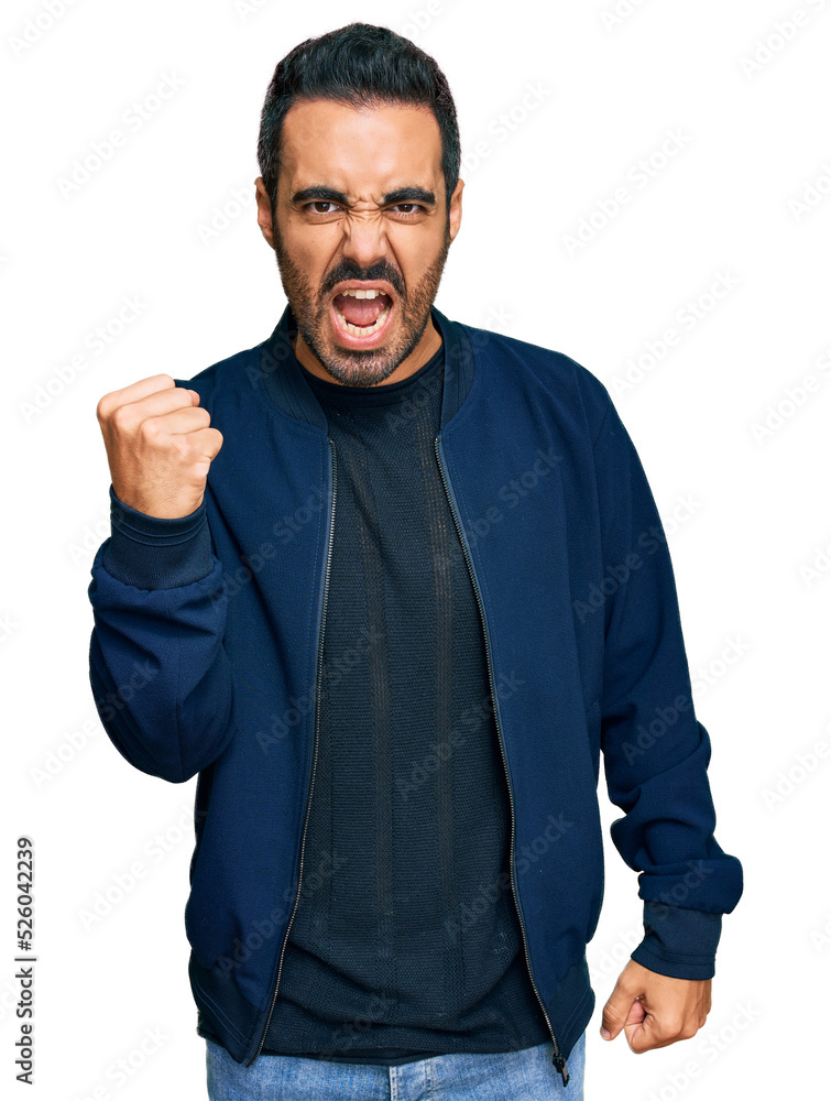Young hispanic man wearing casual clothes angry and mad raising fist frustrated and furious while shouting with anger. rage and aggressive concept. Young hispanic man wearing casual clothes angry and mad raising fist frustrated and furious while shouting with anger. rage and aggressive concept.