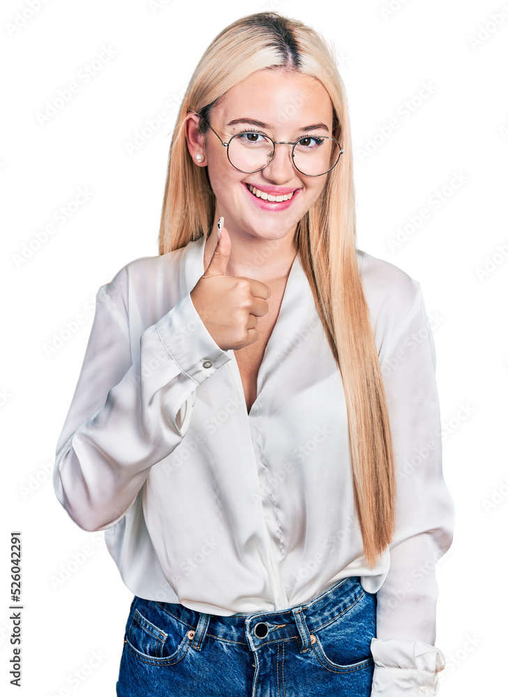 Beautiful blonde woman wearing elegant shirt and glasses doing happy thumbs up gesture with hand. approving expression looking at the camera showing success. Beautiful blonde woman wearing elegant shirt and glasses doing happy thumbs up gesture with hand. approving expression looking at the camera showing success.
