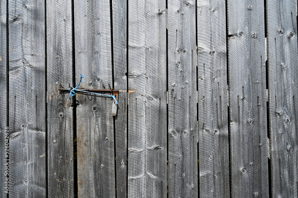 Wooden texture. Old wooden door at the house. Old and dry boards. Gray wooden background. Wooden texture. Old wooden door at the house. Old and dry boards. Gray wooden background.