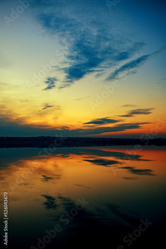 A wonderful dawn on the river with a reflection in the water. vertical
