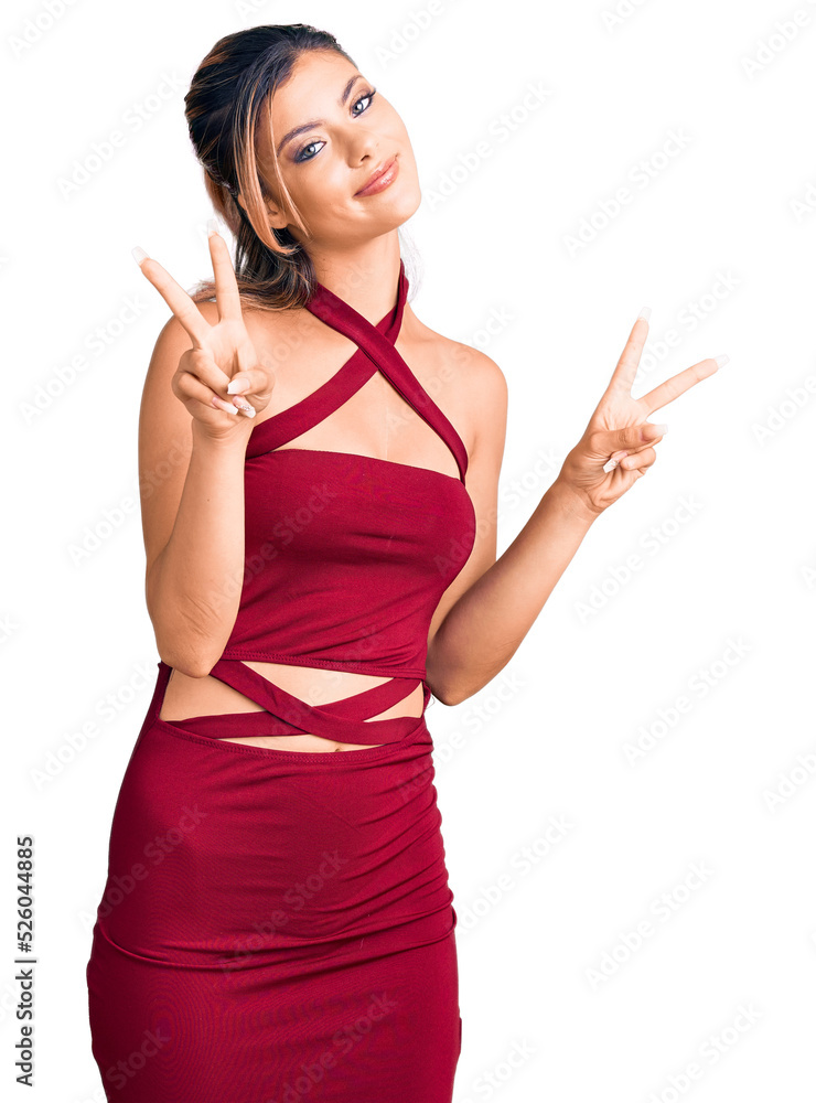 Young beautiful woman wearing casual clothes smiling looking to the camera showing fingers doing victory sign. number two.
