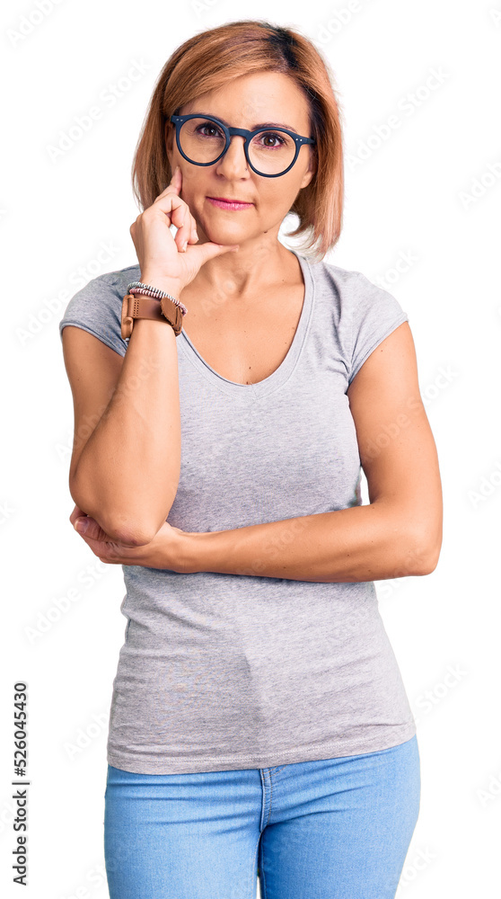 Young blonde woman wearing casual clothes with hand on chin thinking about question, pensive expression. smiling with thoughtful face. doubt concept. Young blonde woman wearing casual clothes with hand on chin thinking about question, pensive expression. smiling with thoughtful face. doubt concept.