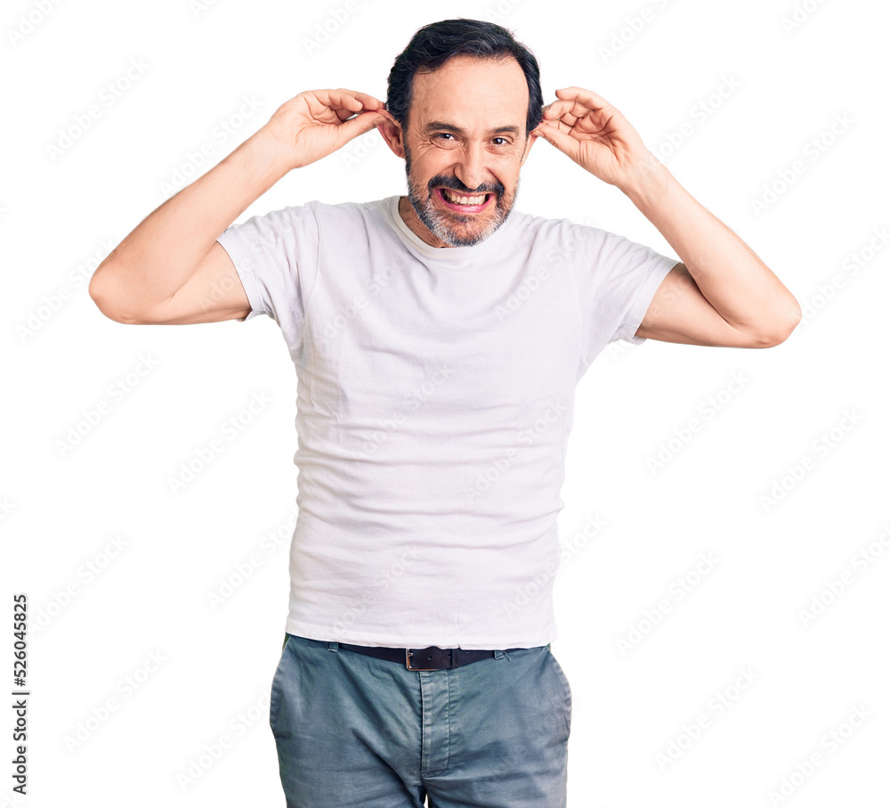 Middle age handsome man wearing casual t-shirt smiling pulling ears with fingers, funny gesture. audition problem Middle age handsome man wearing casual t-shirt smiling pulling ears with fingers, funny gesture. audition problem