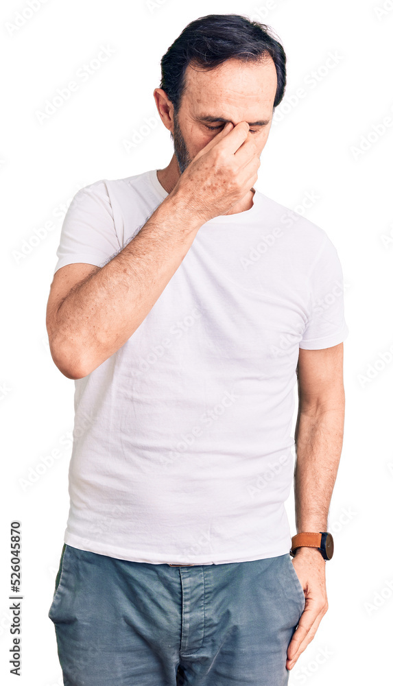 Middle age handsome man wearing casual t-shirt tired rubbing nose and eyes feeling fatigue and headache. stress and frustration concept. Middle age handsome man wearing casual t-shirt tired rubbing nose and eyes feeling fatigue and headache. stress and frustration concept.