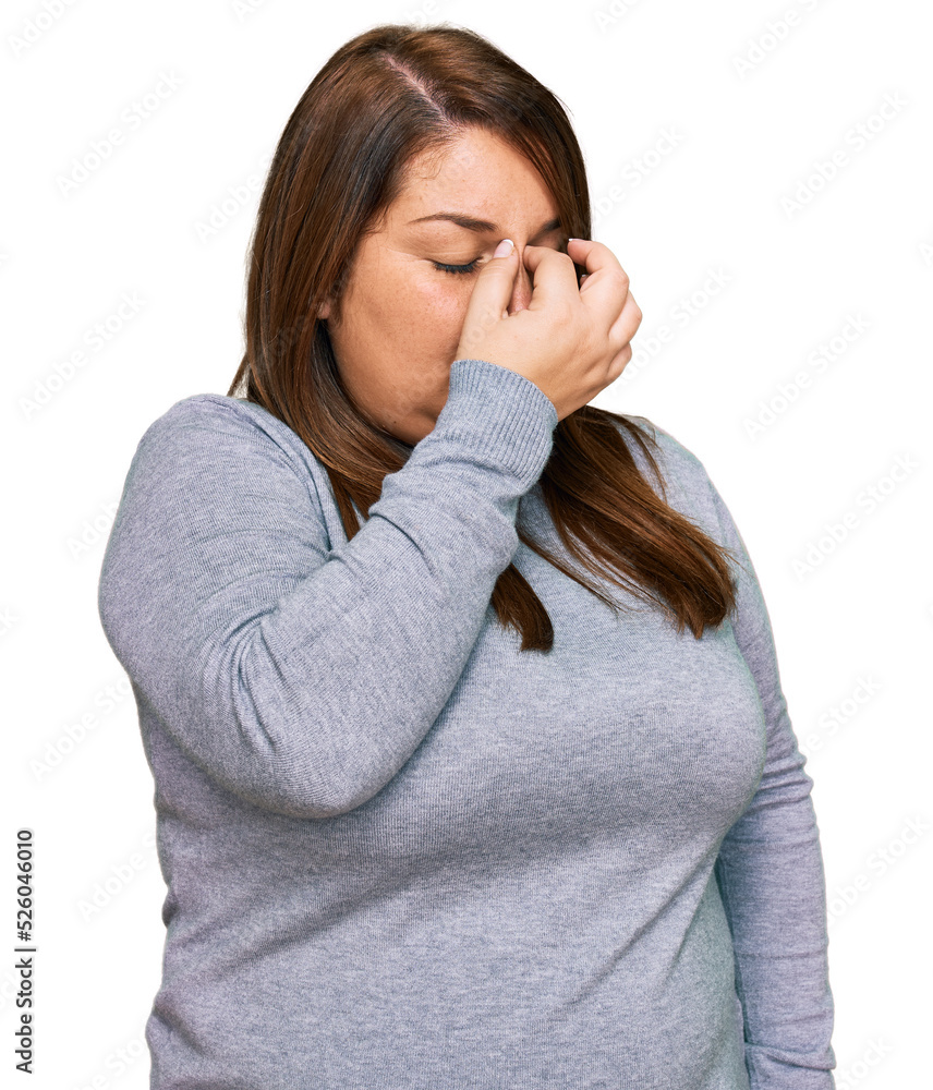Beautiful brunette plus size woman wearing casual clothes tired rubbing nose and eyes feeling fatigue and headache. stress and frustration concept. Beautiful brunette plus size woman wearing casual clothes tired rubbing nose and eyes feeling fatigue and headache. stress and frustration concept.