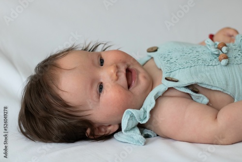 Close-up shot of a cute baby toddler on a white fabri photo