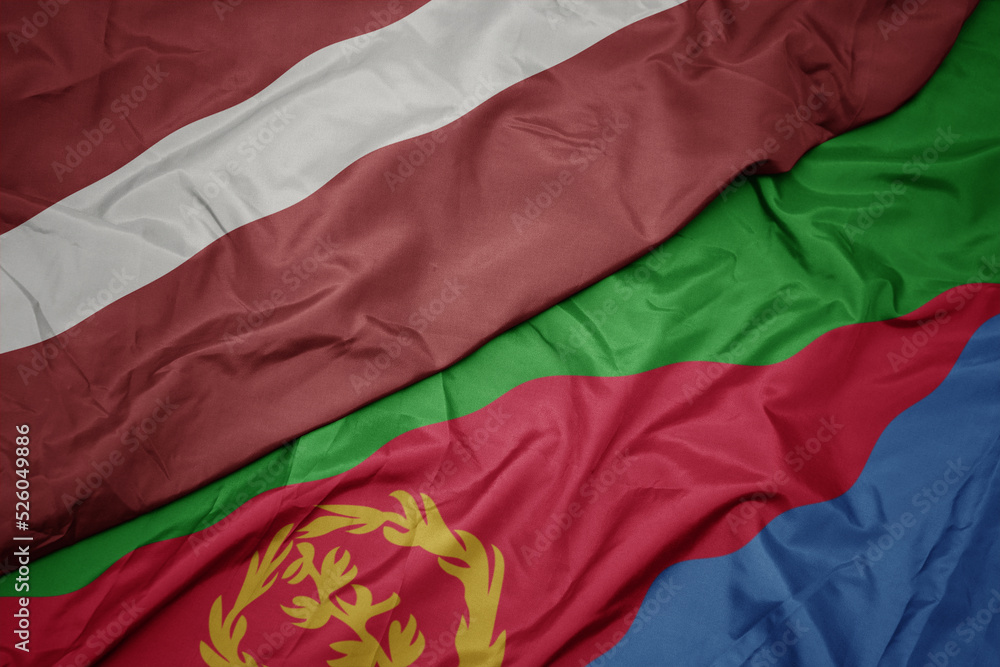 waving colorful flag of eritrea and national flag of latvia.