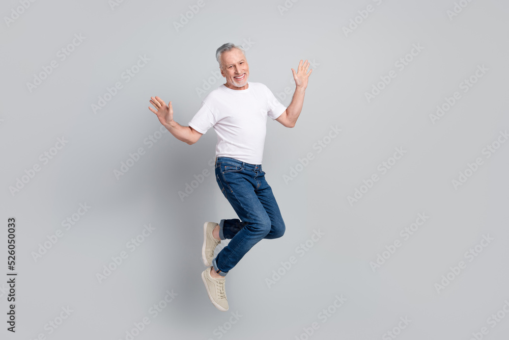 Full length body size view of attractive cheerful successful man jumping having fun isolated over grey pastel color background Full length body size view of attractive cheerful successful man jumping having fun isolated over grey pastel color background