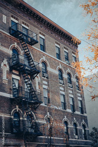 Edificio típico de Manhattan en Nueva York, con ladrillos marrones y escalera de emergencia exterior.