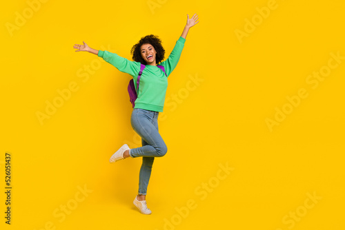 Full length portrait of satisfied carefree girl raise opened hands have fun isolated on yellow color background