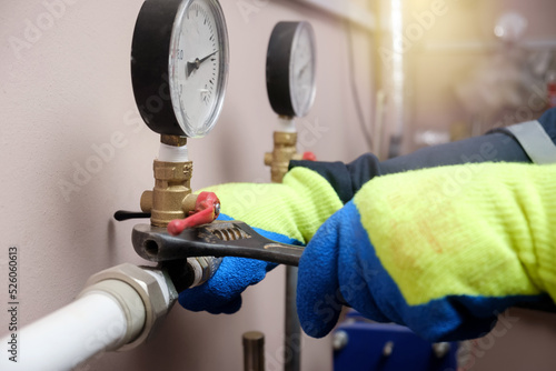 Plumber technician works with water pressure meter in boiler room © silentalex88