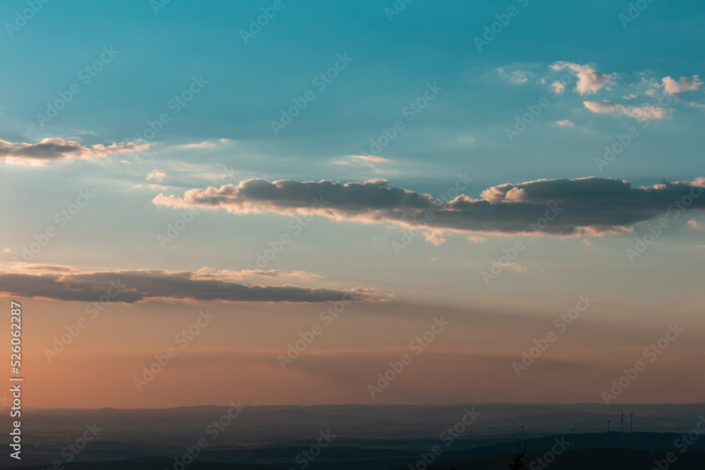 Wide view Feldberg during sunset. Feldberg mountain in Hesse, Germany. Blue sky with few clouds, wide landscape with hills in background.