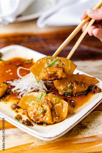 Delicious pork dumplings covered with Japanese ponzu sauce photo