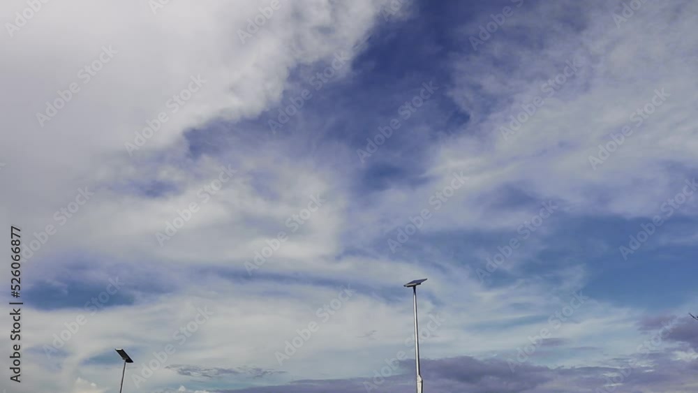 The movement of the clouds that were clustered and scattered across the sky with solar cell lamp pole. time lapse The movement of the clouds that were clustered and scattered across the sky with solar cell lamp pole. time lapse