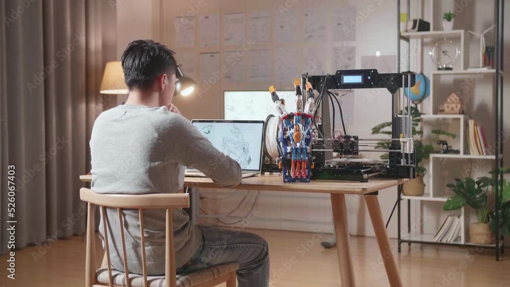 Back View Of A Male With 3D Printing Thinking While Designing A Cyborg Hand On A Laptop At Home
Back View Of A Male With 3D Printing Thinking While Designing A Cyborg Hand On A Laptop At Home