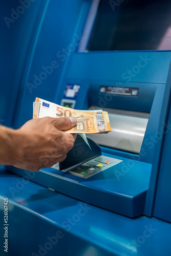 Mann hebt Geld am Bankautomaten ab