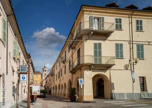 Fossano, Cuneo, Italy - August 25, 2022: the historic center with via Cavour, pedestrian street with arcades and the civic bell tower at the bottom, blue sky with clouds © framarzo