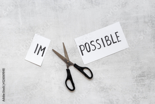 It is possible concept. Word Impossible becomes Possible with scissors photo