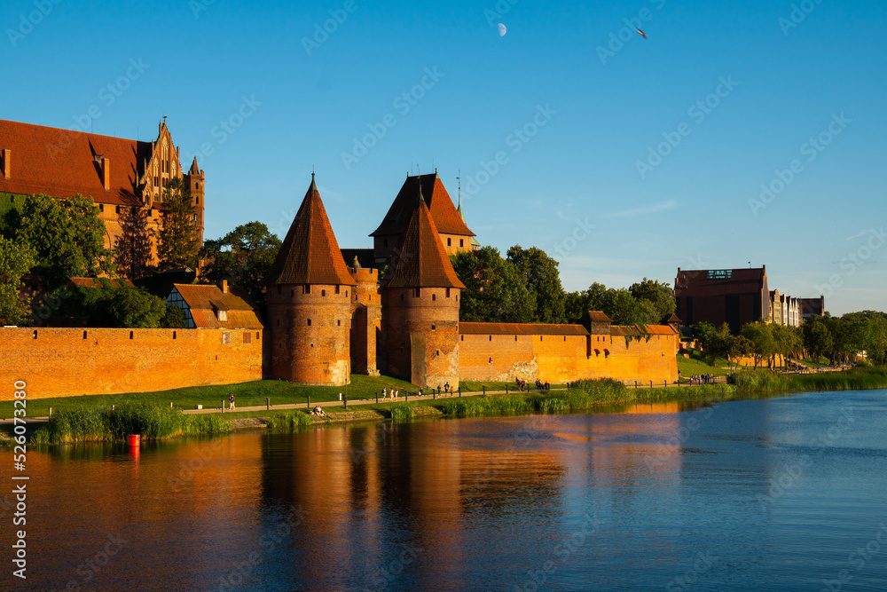Obraz premium Marienburg Castle the largest medieval brick castle in the world in the city of Malbork at sunset