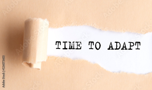 The text TIME TO ADAPT appears on torn paper on white background.