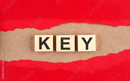 KEY word on a wooden cubes on red torn paper , financial concept background